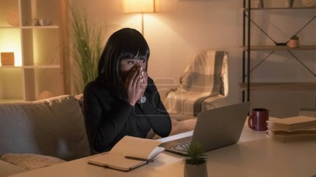 Photo for Shocked news. Excited woman. Online connection. Happy female student looking laptop covering mouth with hands in evening room interior. - Royalty Free Image
