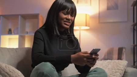 Photo for Negative communication. Troubled woman. Shocked news. Confused dissatisfied female feeling disturbed reading message in smartphone sitting home interior. - Royalty Free Image