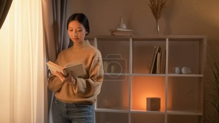 Photo for Book lover. Curious woman. Home leisure. Smart female enjoying reading posing near window in light room interior. - Royalty Free Image