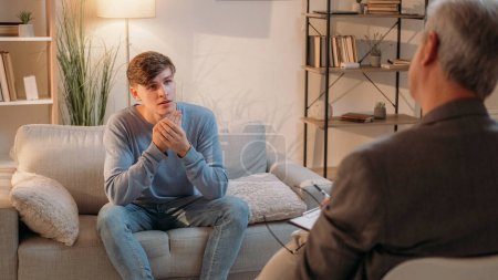 Photo for Counseling therapy. Psychology treatment. Healthcare consultation. Psychologist discussing mental health of curious man on session light room interior. - Royalty Free Image