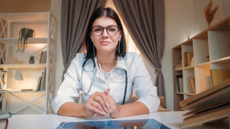 Photo for Virtual doctor. Online healthcare. Distance consultation. Woman general practitioner listening to patient on remote meeting at hospital workplace. - Royalty Free Image
