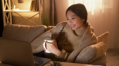 Photo for Home movie. Evening leisure. Weekend rest. Relaxed happy woman enjoying show on laptop with coffee alone on cozy couch. - Royalty Free Image