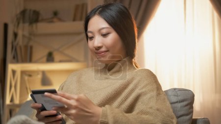 Photo for Bank app. Electronic money. Digital payment. Happy satisfied woman using credit card for mobile phone in home interior. - Royalty Free Image