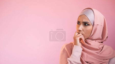 Photo for Concerned woman. Idea contemplation. Pensive perplexed girl in hijab thinking considering isolated on pink empty space advertising background. - Royalty Free Image