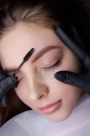 Photo for Macro photo after the procedure of permanent eyebrow makeup master combing the eyebrows with a brush. PMU Procedure, Permanent Eyebrow Makeup. - Royalty Free Image