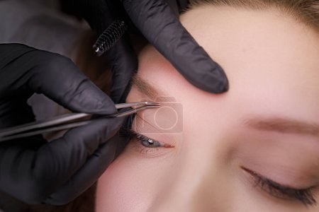 Macro photo of eyebrows which the master corrects before the procedure of permanent makeup. PMU Procedure, Permanent Eyebrow Makeup.