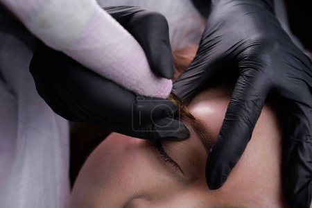 Photo for Technique of air application of permanent makeup on the model's eyebrows. PMU Procedure, Permanent Eyebrow Makeup. - Royalty Free Image