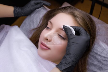 Photo for The permanent makeup artist prepares the model's eyebrows. PMU Procedure, Permanent Eyebrow Makeup. - Royalty Free Image