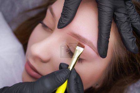 Photo for Correction of the shape of the markings applied with a brush before the permanent makeup procedure. PMU Procedure, Permanent Eyebrow Makeup. - Royalty Free Image