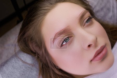 Cute girl model with markings on her eyebrows before permanent makeup procedure. PMU Procedure, Permanent Eyebrow Makeup.