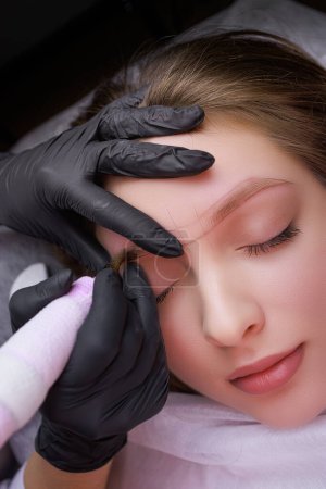 Photo for Master's hands close-up of permanent eyebrow makeup. PMU Procedure, Permanent Eyebrow Makeup. - Royalty Free Image