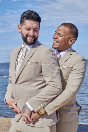 Foto de Dos tipos celebrando la diversidad, su amor hecho público en la playa. Salen del armario. Orgullo de la comunidad LGBT. - Imagen libre de derechos