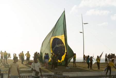 Foto de Salvador, Bahia, Brasil - 22 de octubre de 2022: Partidarios del presidente de Brasil, Jair Bolsonaro, protestan colocando una gran bandera brasileña en la plaza Farol da Barra en Salvador. - Imagen libre de derechos