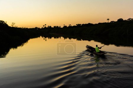 Téléchargez les photos : Aratuipe, Bahia, Brésil - Le 31 août 2018 : Un pêcheur pagayant sur la rivière Jaguaripe, ville d'Aratuipe, au coucher du soleil. - en image libre de droit