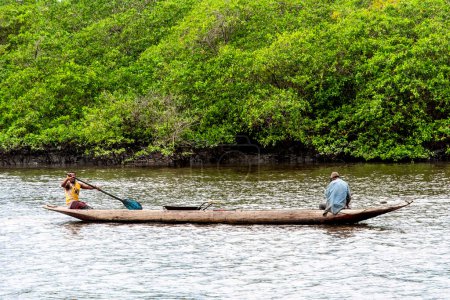 Téléchargez les photos : Aratuipe, Bahia, Brésil - 31 août 2018 : Deux pêcheurs en canot naviguant sur la rivière Jaguaripe dans la ville d'Aratuipe, Bahia. - en image libre de droit