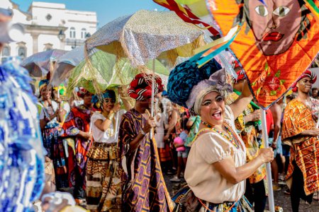 Photo for Salvador, Bahia, Brazil - February 11, 2018: Members of the traditional carnival block Filhos de Gandy parade in the streets of Salvador, Bahia during the 2018 carnival. - Royalty Free Image