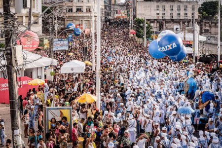Foto de Salvador, Bahia, Brazil - February 11, 2018: Crowd of members of the traditional carnival group Filhos de Gandy, parade in the streets of Salvador, Bahia, during Carnival. - Imagen libre de derechos