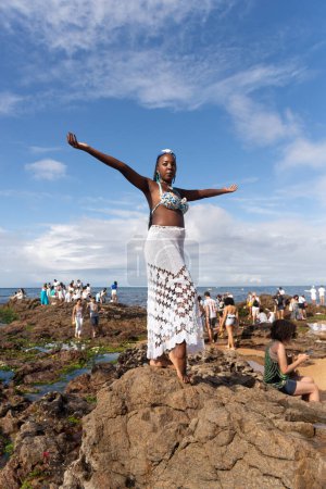 Photo for Salvador, Bahia, Brazil - February 02, 2023: People are seen on top of the rocks at Rio Vermelho beach, offering gifts to Yemanja, in Salvador, Bahia. - Royalty Free Image