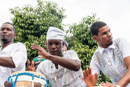 Photo for Santo Amaro, Bahia, Brazil - May 15, 2022: Candomble members are seen playing and singing during the Bembe do Mercado religious festivities in Santo Amaro, Bahia. - Royalty Free Image