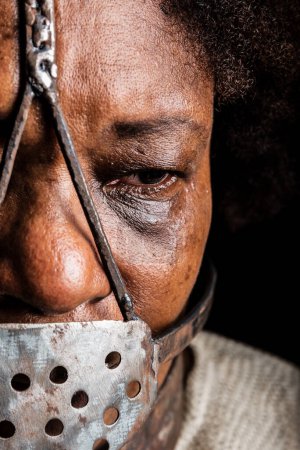 Photo for Close-up portrait of a black woman wearing an iron mask on her face to represent the slave Anastacia. Slavery in Brazil. - Royalty Free Image