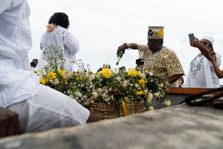 Photo for Santo Amaro, Bahia, Brazil - May 15, 2022: Candomble people carrying offerings to Iemanja during the Bembe do Mercado celebrations. Itapema Beach, Santo Amaro. - Royalty Free Image