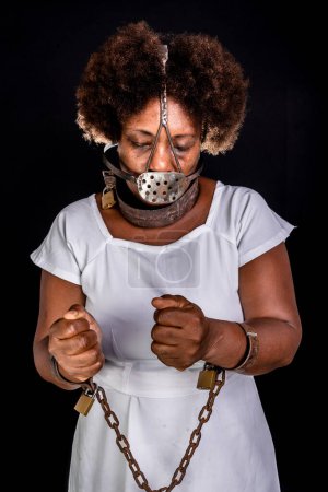 Photo for Portrait of a black woman in chains with an iron mask on her face, representing the slave Anastacia. Slavery in Brazil. - Royalty Free Image