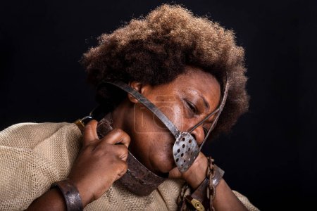 Téléchargez les photos : Portrait d'une femme noire emprisonnée avec un masque de fer sur le visage représentant l'esclave Anastacia. Esclavage au Brésil. - en image libre de droit