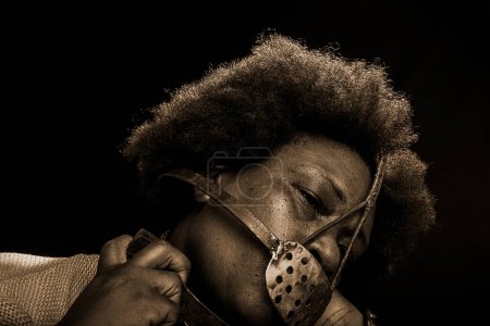 Photo for Face portrait of a black woman imprisoned with an iron mask on her face representing the slave Anastacia. Slavery in Brazil. - Royalty Free Image