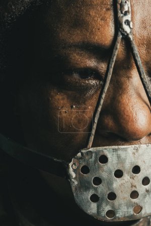 Téléchargez les photos : Gros plan portrait d'une femme noire portant un masque de fer sur son visage pour représenter l'esclave Anastacia. Esclavage au Brésil. - en image libre de droit