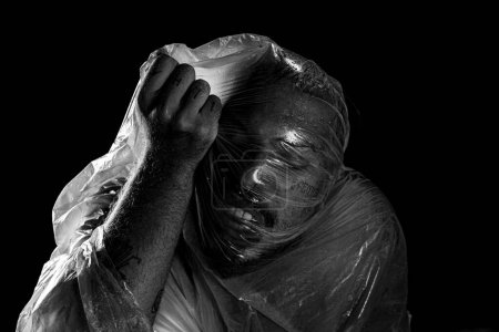 Foto de Hombre con bolsa de plástico en la cabeza, asfixiado. Tiro blanco y negro. expresión del dolor. - Imagen libre de derechos