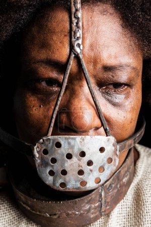 Photo for Close-up portrait of a black woman wearing an iron mask on her face to represent the slave Anastacia. Slavery in Brazil. - Royalty Free Image