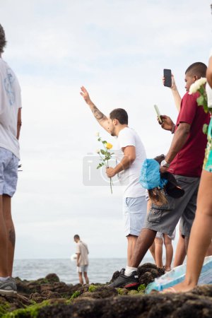 Photo for Salvador, Bahia, Brazil - February 02, 2023: Candomble fans are seen paying homage to Yemanja on Rio Vermelho beach in Salvador, Bahia. - Royalty Free Image