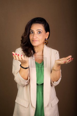 Photo for Portrait smiling and confident coaching woman making hand gestures. Motivational and democratic management. Isolated on brown background. - Royalty Free Image