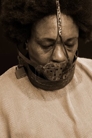 Photo for Black woman in chains with an iron mask on her face, representing the slave Anastacia. sadness and apathy, pain. Slavery in Brazil. - Royalty Free Image