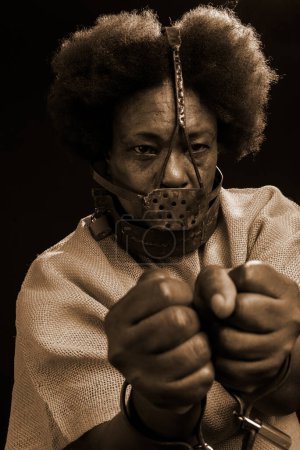 Photo for Black woman in chains with an iron mask on her face, representing the slave Anastacia. sadness and apathy, pain. Slavery in Brazil. - Royalty Free Image