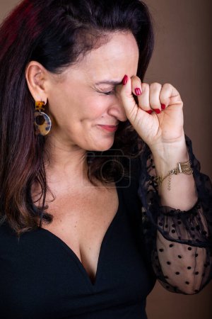 Photo for Portrait of a coaching woman, happy, with her hands on her face and her eyes closed. Motivational management. Isolated on brown background. - Royalty Free Image