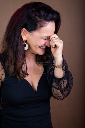 Photo for Portrait of a coaching woman, happy, with her hands on her face and her eyes closed. Motivational management. Isolated on brown background. - Royalty Free Image