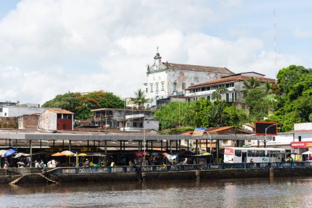 Foto de Valenca, Bahia, Brasil - 10 de enero de 2023: Vista de la iglesia Matriz con los edificios comerciales y el río Una abajo. Ciudad turística de Valenca en el estado brasileño de Bahía. - Imagen libre de derechos
