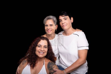 Téléchargez les photos : Trois belles femmes, lesbiennes, musiciens amis et heureux de poser pour la caméra. Portrait studio sur fond noir. - en image libre de droit
