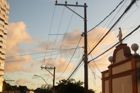 Téléchargez les photos : Salvador, Bahia, Brésil - 23 avril 2022 : Vue d'un bâtiment, d'arbres et de poteaux électriques dans une rue de la ville de Salvador, Bahia. - en image libre de droit