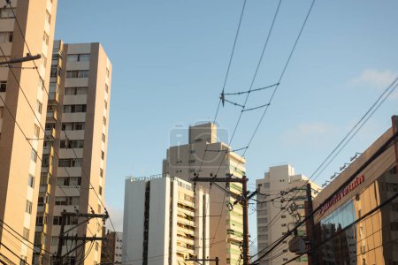 Téléchargez les photos : Salvador, Bahia, Brésil - 23 avril 2022 : Vue d'un bâtiment, d'arbres et de poteaux électriques dans une rue de la ville de Salvador, Bahia. - en image libre de droit