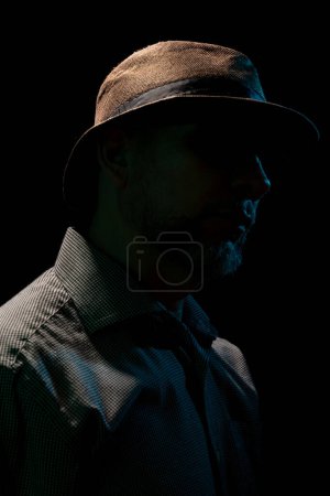Foto de Un hombre misterioso con sombrero y gafas de sol. Retrato en estudio oscuro. - Imagen libre de derechos