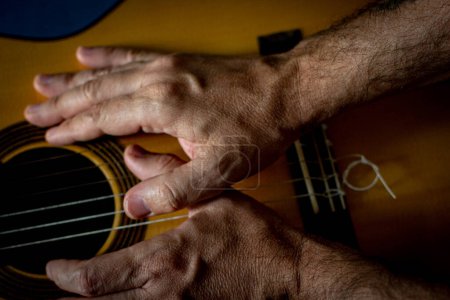 Photo for Hands of a classical guitarist on top of the guitar. - Royalty Free Image