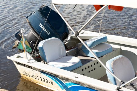 Téléchargez les photos : Aratuipe, Bahia, Brésil - 30 mai 2015 : Un bateau de plaisance avec un moteur Yamaha arrêté sur la rivière Jaguaripe à Maragogipinho, un quartier de la ville d'Aratuipe à Bahia. - en image libre de droit