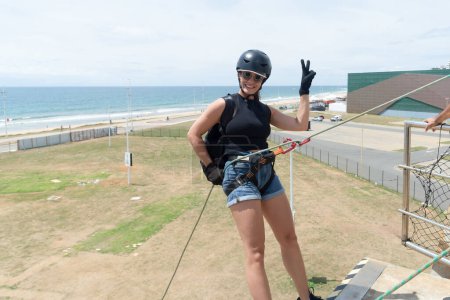 Salvador, bahia, Brazil - January 07, 2024: Rappelling woman giving a thumbs up before descending from a great height. Healthy sport. Lifestyle.