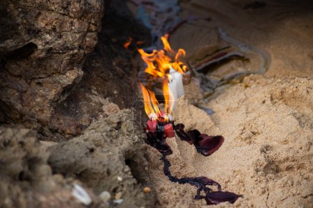 Photo for Candles burning among rocks on a beach to honor some religious entity. Salvador, Bahia. - Royalty Free Image