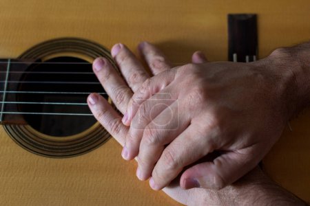 Hands on top of a classical guitar. Quality music