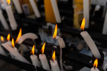 Several lit candles burning during the day.