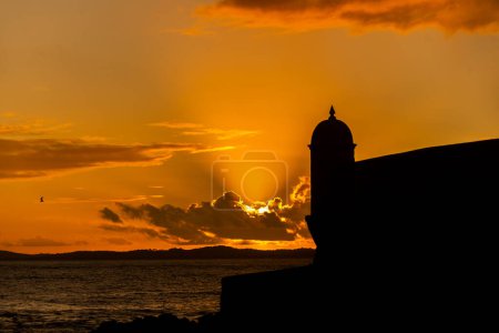 Silhouette of the tip of a nautical fort. Dramatic and orange sunset.