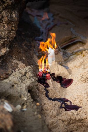 Bougies brûlant parmi les rochers sur une plage pour honorer une entité religieuse. Salvador, Bahia.